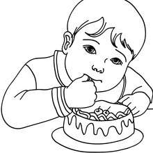 Junge isst Geburtstagskuchen zum Ausmalen